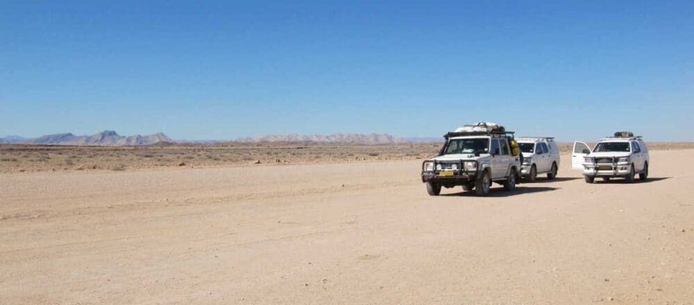 Headerbild: Autos auf einer Schotterpiste - Dusty Trails Safaris Namibia & Dusty Car Hire Namibia