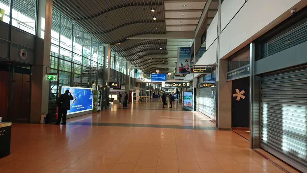 Gate-Bereich am Hamburger Flughafen mit wenig Menschen und geschlossenen Geschäften